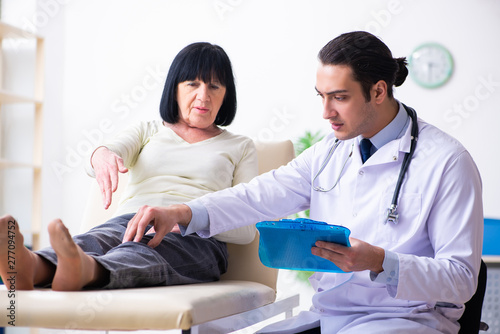 Young doctor examining senior old woman