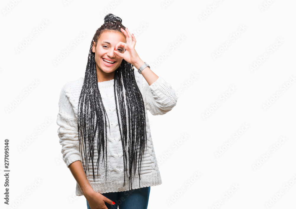 Young braided hair african american girl wearing sweater over isolated background doing ok gesture with hand smiling, eye looking through fingers with happy face. Young braided hair african american girl wearing sweater over isolated background doing ok gesture with hand smiling, eye looking through fingers with happy face.