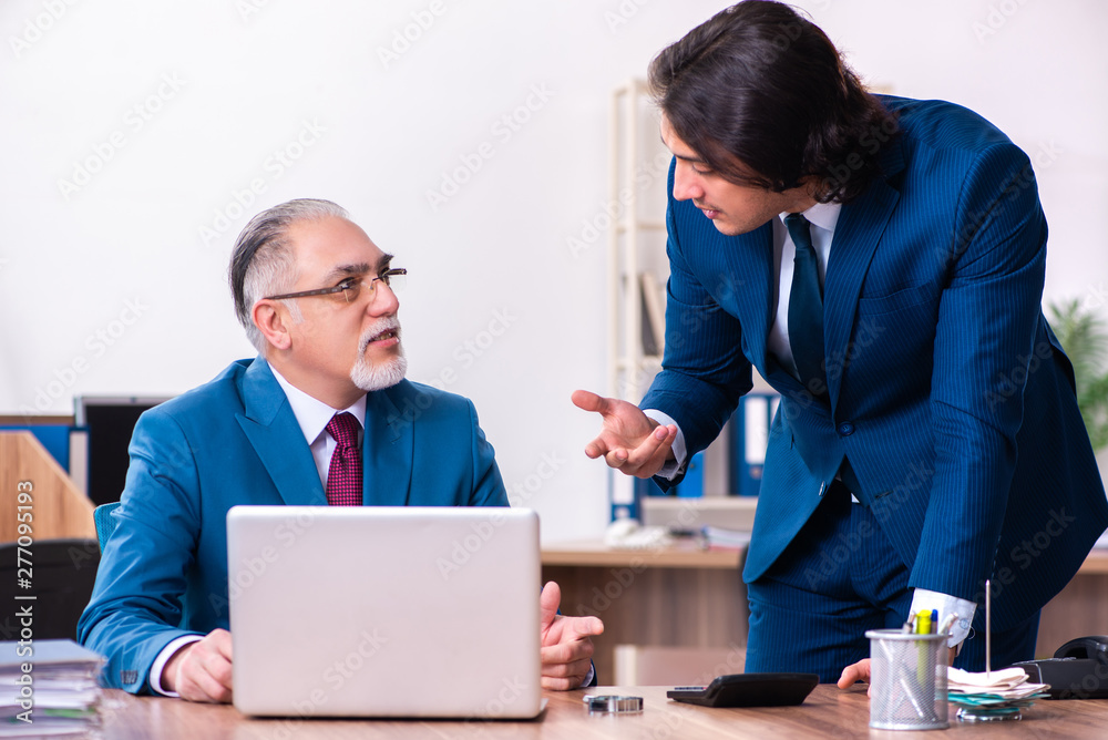 Young and old employees working together in the office Young and old employees working together in the office