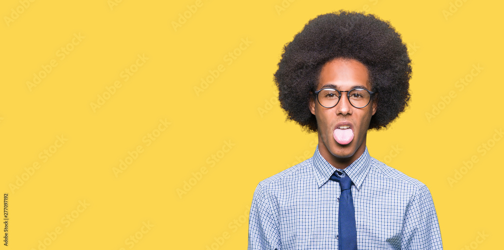 Young african american business man with afro hair wearing glasses sticking tongue out happy with funny expression. Emotion concept. Young african american business man with afro hair wearing glasses sticking tongue out happy with funny expression. Emotion concept.