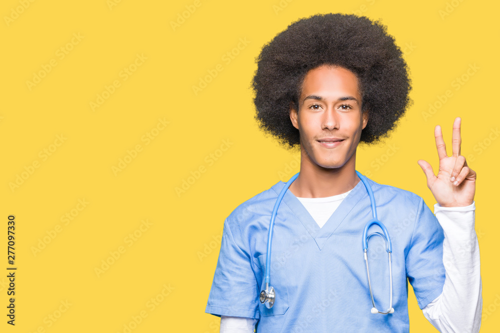 Young african american doctor man with afro hair showing and pointing up with fingers number three while smiling confident and happy. Young african american doctor man with afro hair showing and pointing up with fingers number three while smiling confident and happy.
