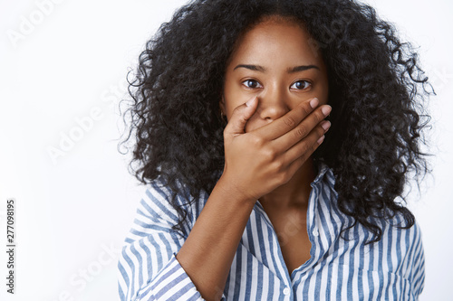 Shocked african american woman gasping amazed hearing stunning unbelievable news press palm mouth astonished gossiping found out shocking truth, standing stunned speechless, white background © Cookie Studio