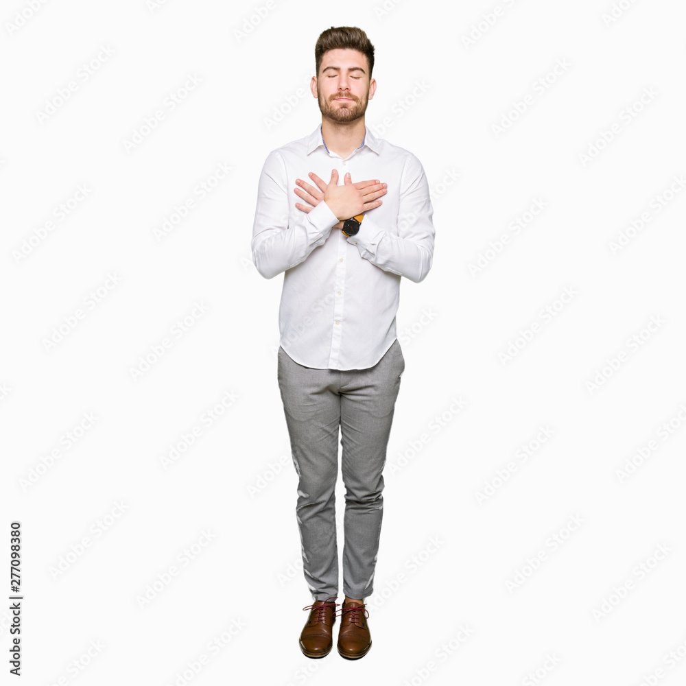 Young handsome business man smiling with hands on chest with closed eyes and grateful gesture on face. Health concept. Young handsome business man smiling with hands on chest with closed eyes and grateful gesture on face. Health concept.