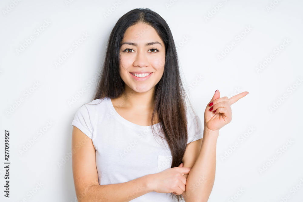 Beautiful brunette woman over isolated background with a big smile on face, pointing with hand and finger to the side looking at the camera. Beautiful brunette woman over isolated background with a big smile on face, pointing with hand and finger to the side looking at the camera.