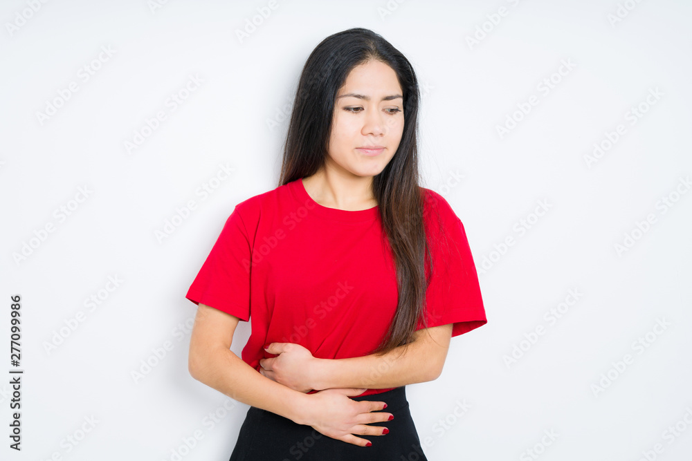 Beautiful brunette woman wearing red t-shirt over isolated background with hand on stomach because nausea, painful disease feeling unwell. Ache concept. Beautiful brunette woman wearing red t-shirt over isolated background with hand on stomach because nausea, painful disease feeling unwell. Ache concept.