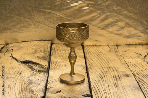 Photography golden wine goblet isolated on golden wooden background