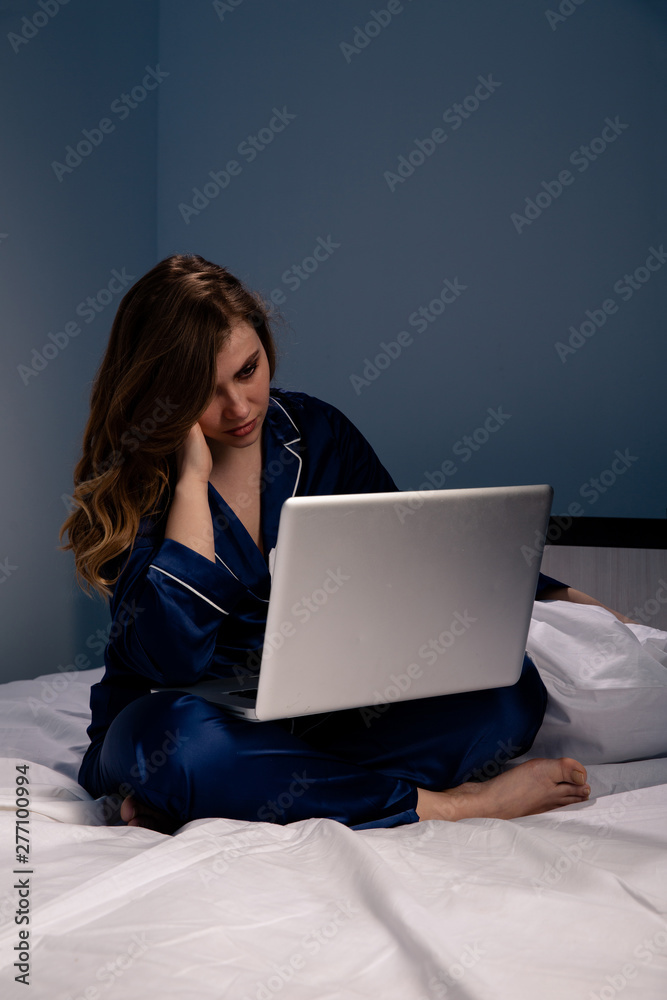Frustrated woman at home sitting on the bed with computer Frustrated woman at home sitting on the bed with computer