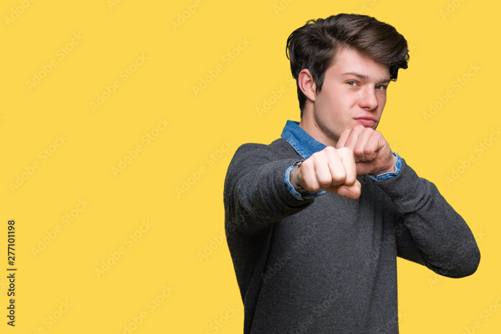 Young handsome elegant man over isolated background Punching fist to fight, aggressive and angry attack, threat and violence Young handsome elegant man over isolated background Punching fist to fight, aggressive and angry attack, threat and violence