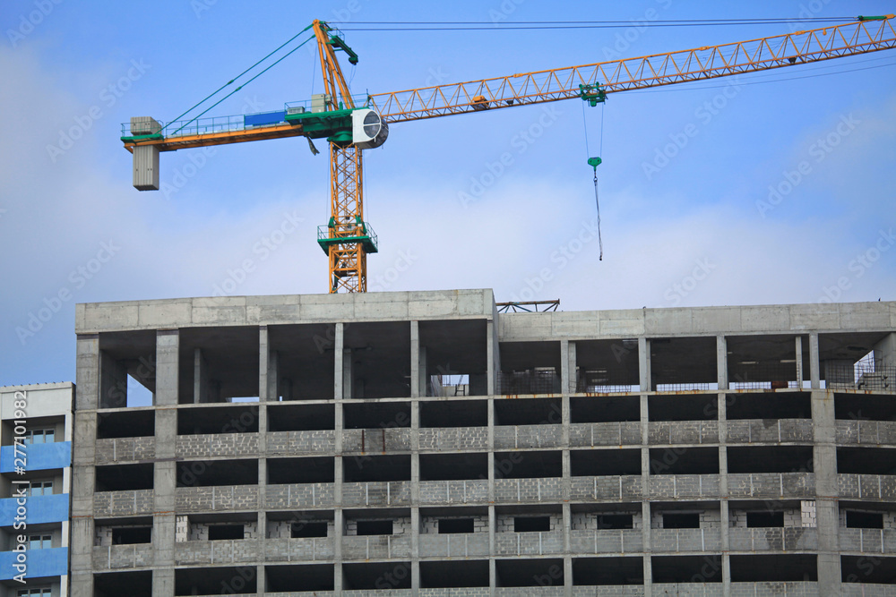 Construction site, crane and multi-storey building. Frozen building сonstruction. Unfinished and abandoned apartment monolithic residential house. Property tax Construction site, crane and multi-storey building. Frozen building сonstruction. Unfinished and abandoned apartment monolithic residential house. Property tax