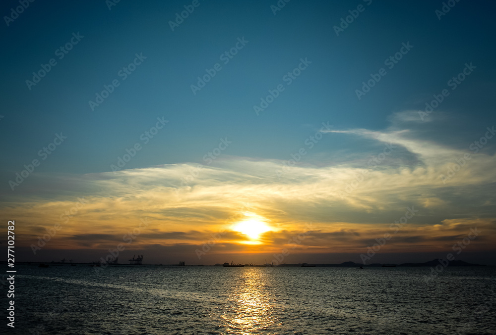 Sunset at sea with clouds and silhouette of island