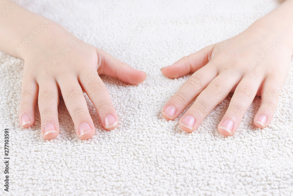 Naklejka premium child's hands with long nails, towel, closeup