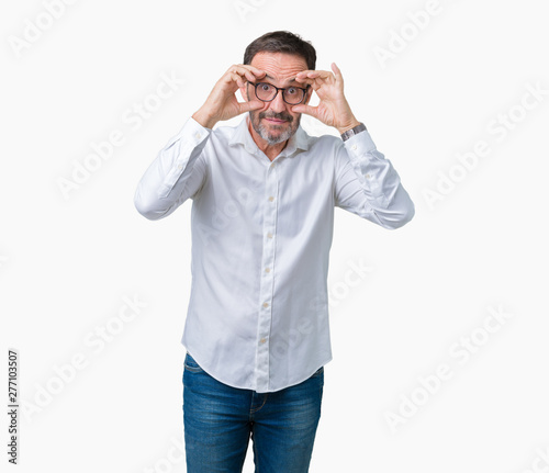 Handsome middle age elegant senior business man wearing glasses over isolated background Trying to open eyes with fingers, sleepy and tired for morning fatigue