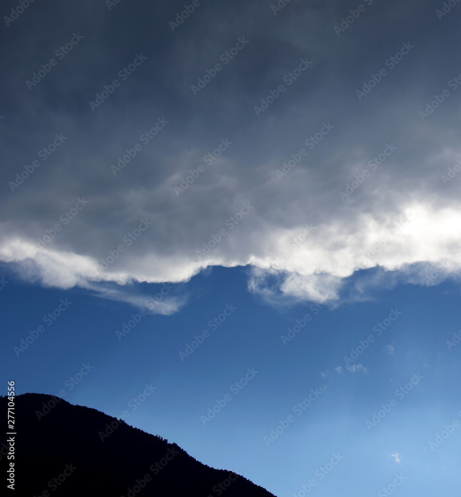 Obraz premium Dunkle Wolkendecke über blauen Himmel