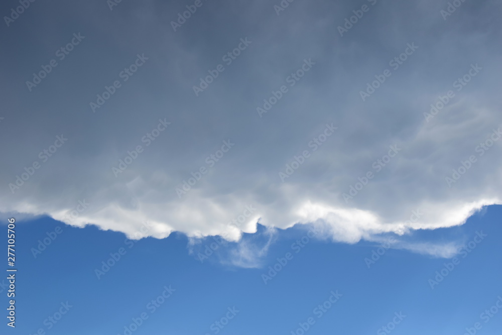 Dunkle Wolkendecke über blauen Himmel