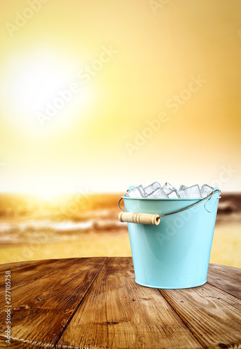 Wooden desk of free space and summer background with ice cubes 