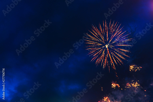 Inexpensive fireworks over the city sky, red, blue and white. Bright and shiny. Selective focus. For any purpose. Celebration concept.