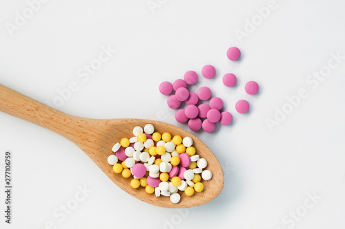 wooden spoon with pills isolated on white background