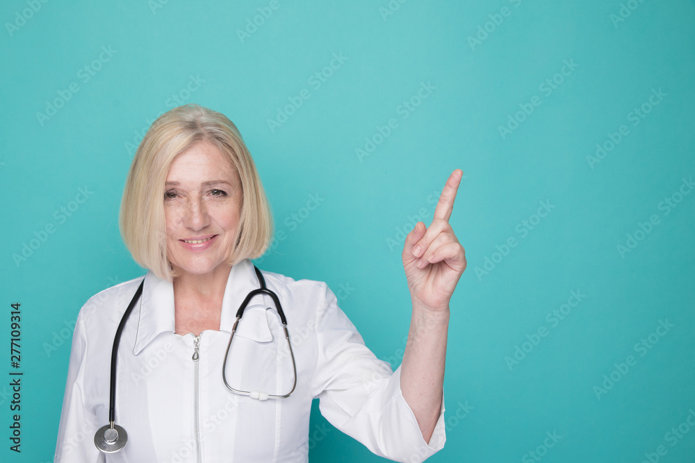 Portrait of female doctor pointing something isolated in the blue studio Portrait of female doctor pointing something isolated in the blue studio
