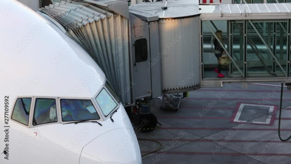 Aircraft with passage corridor/tunnel being prepared for departure from an international airport - Passangers boarding an airplane in a modern airport