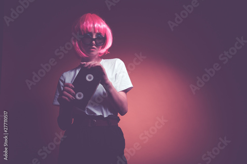 Young girl 90s and VHS cassette on pink background.