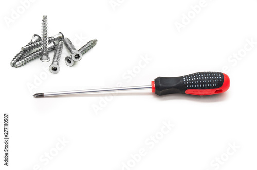 Shiny metal screwdriver for repair with a plastic black and red handle and Screws still life large self tapping, the concept of manual labor and repair. Red screwdriver isolated on white background. photo