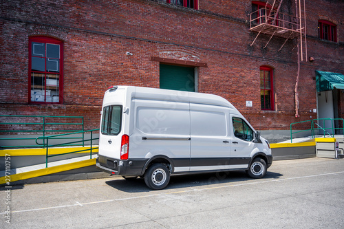 Fototapeta White compact popular cargo mini van for local deliveries and business standing