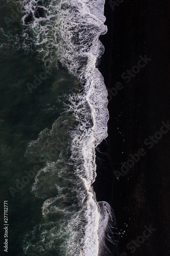 Overhead view of scenic sea waves on black sand beach in Iceland