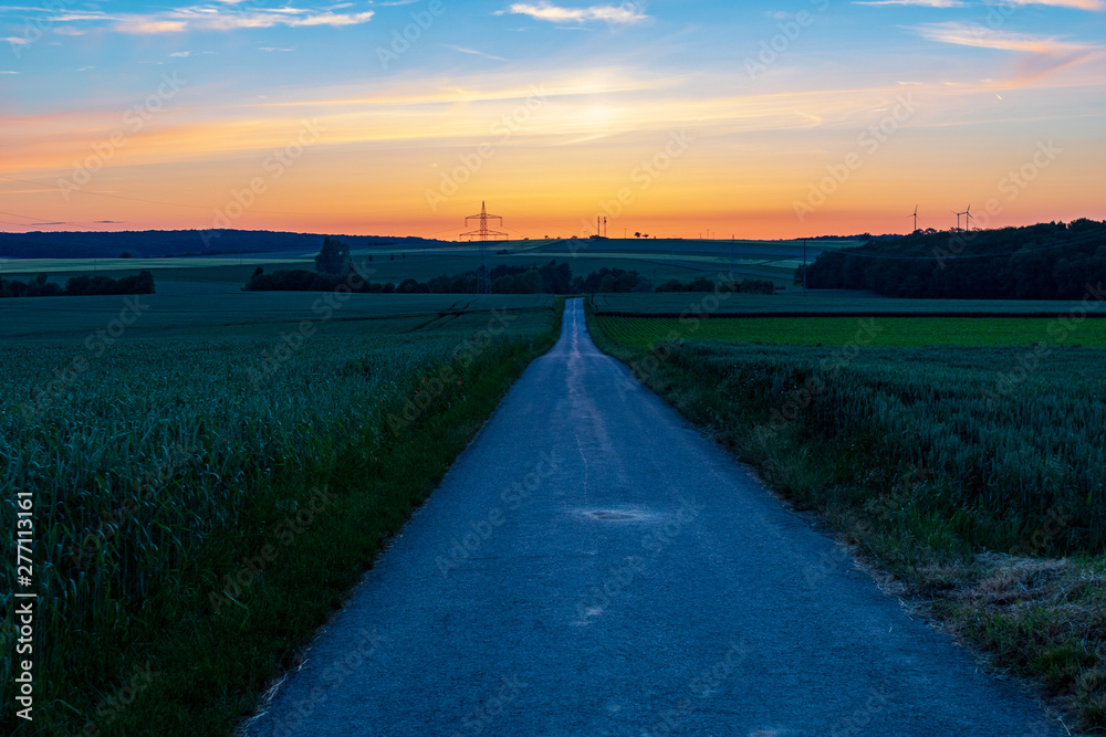 Empty straight road in rural landscape with evening sky. Hope concept