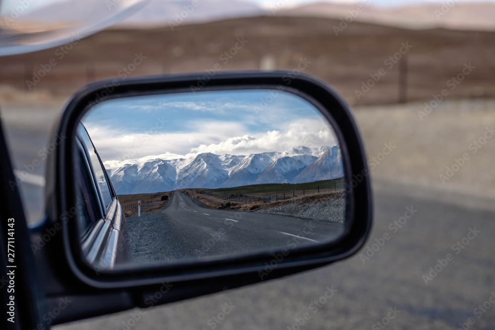 Side view mirror from car travel road trip scenery mountain in New Zealand.