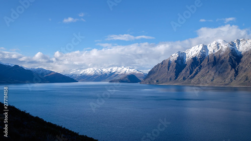 New Zealand travel image of Lake Hawea with snow mountain and blue mirror lake. Peaceful image of natural scenery during winter season in South island, New Zealand.