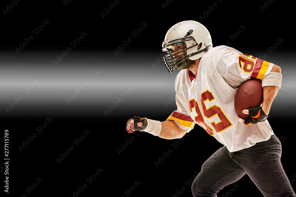 American football player in motion with the ball on a black background with a light line, copy space. The concept of the game is American football, movement. American football player in motion with the ball on a black background with a light line, copy space. The concept of the game is American football, movement.