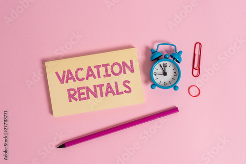 Word writing text Vacation Rentals. Business photo showcasing Renting out of apartment house condominium for a short stay Colorful blank notepad marker retro alarm clock clip colored background photo