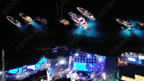 Fototapeta Naklejka Na Ścianę i Meble -  Aerial drone night shot of famous Psarou beach with luxury resorts and yachts docked, Mykonos island, Cyclades, Greece