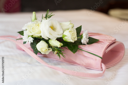 White wedding flowers on pink handbag