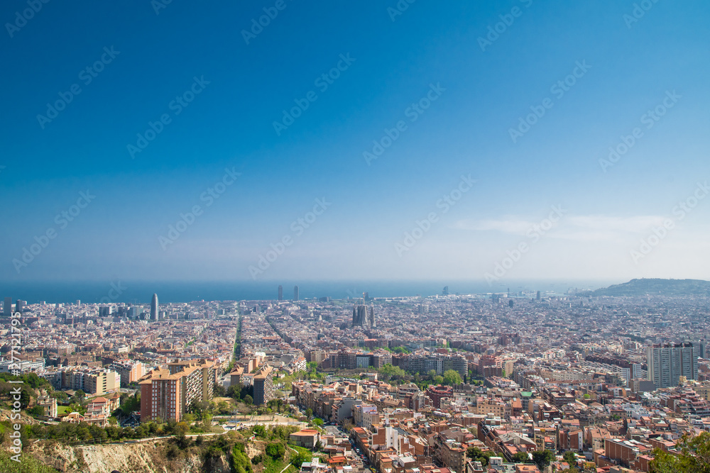 Barcelona, Spain - April, 2019: View of Barcelona city and costline in spring from the Bunkers in Carmel neighborhood. Few building stand out like sagrada familia and Agbar tower