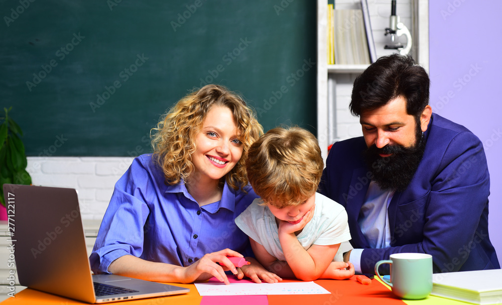 Couple helping his son to make homework. First day at school. Little schoolboy ready to study. Parenting education. September 1. Kid from elementary school with parents in school. Elementary student. Couple helping his son to make homework. First day at school. Little schoolboy ready to study. Parenting education. September 1. Kid from elementary school with parents in school. Elementary student.
