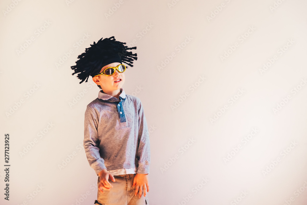 Child with rastafari wig dancing cheerful, isolated copy space white background. Child with rastafari wig dancing cheerful, isolated copy space white background.