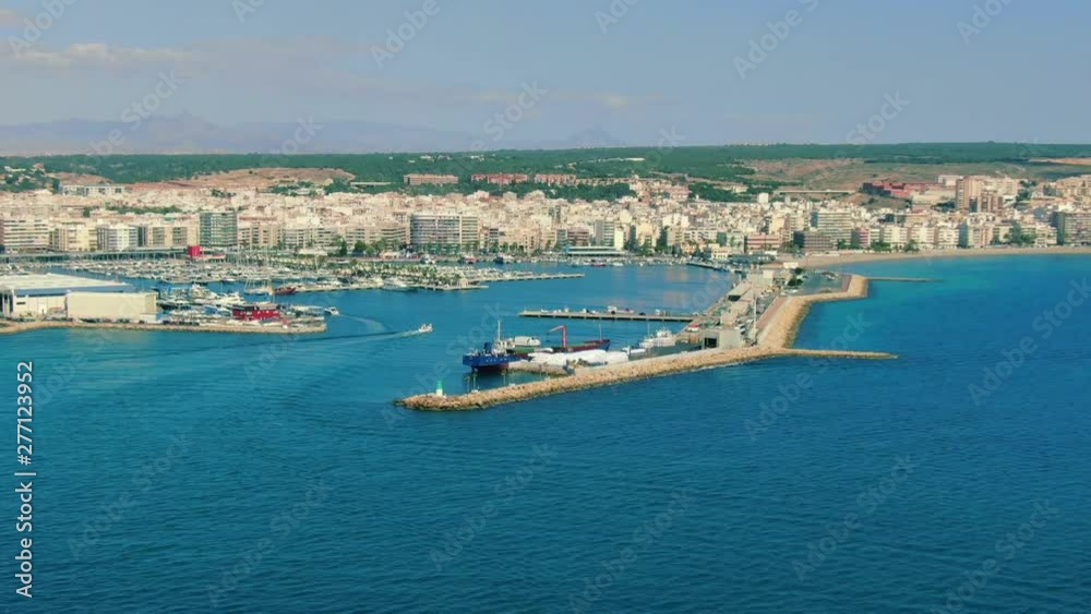 Boats entering marina at fast pace, aerial hyper lapse of Mediterranean marina and the town of Santa Pola in Spain, orbiting pan, copy space Boats entering marina at fast pace, aerial hyper lapse of Mediterranean marina and the town of Santa Pola in Spain, orbiting pan, copy space