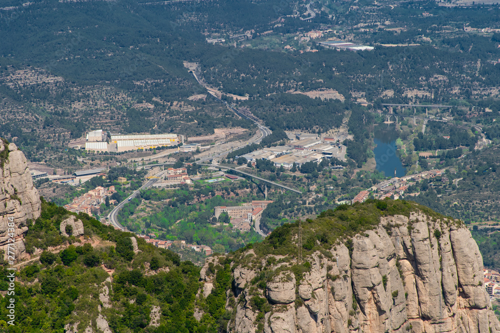 MONSERRAT, SPAIN - April, 2019: Top view of Santa Maria de Montserrat Abbey in Monistrol de Montserrat Montserrat Monastery and big, high rocky mountains on sunny day, Catalonia, Spain