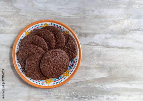 Plate of chocolate crisp cookies on marble countertop