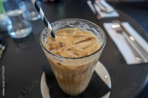 Iced coffee served with a paper straw in a cafe which supports the ban on single use plastics