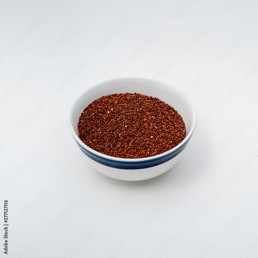 Red Quinoa raw on white background, bowl filed up to three fourths Red Quinoa raw on white background, bowl filed up to three fourths