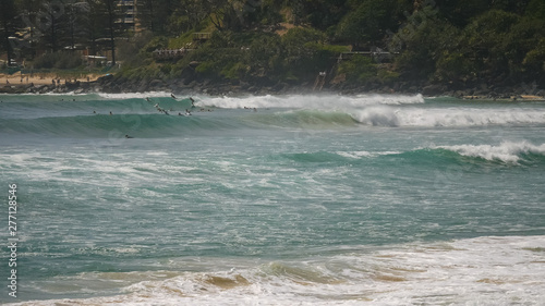 long shot of surfers riding waves at greenmount on the gold coast of queensland