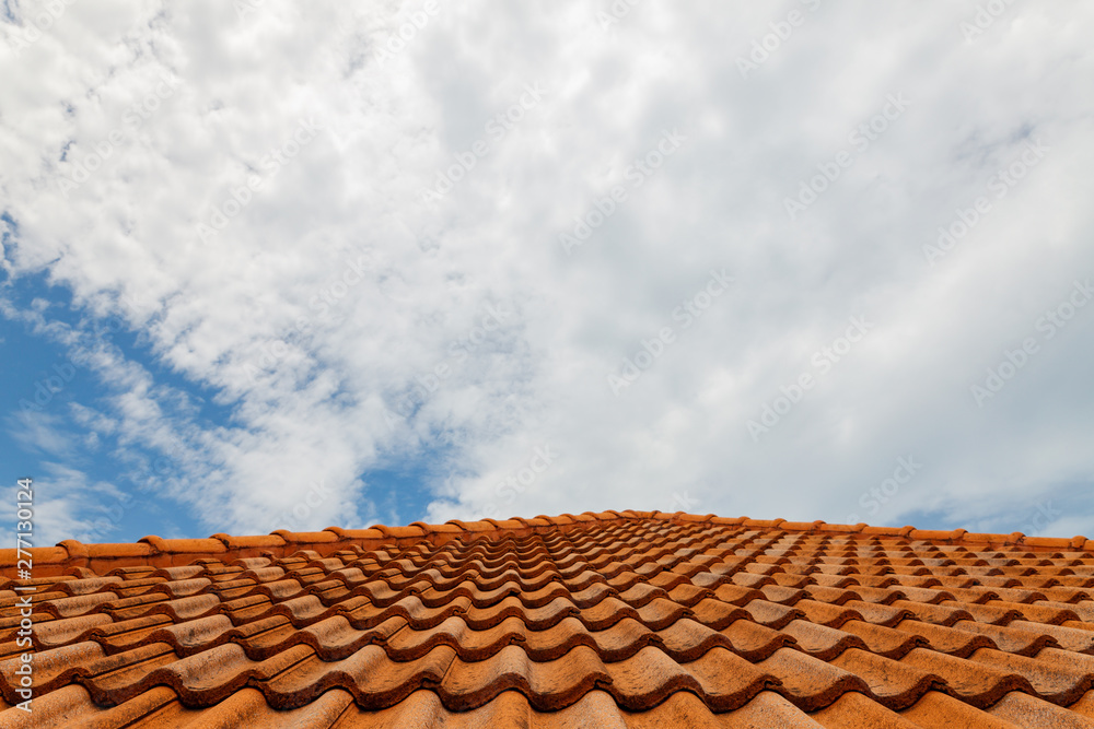 Naklejka premium Close up of brown clay roof tiles. Red old dirty roof. Old roof tiles. Construction equipment build a house.