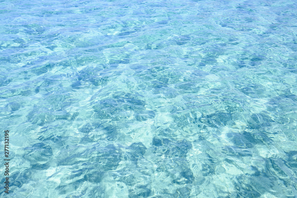 Fototapeta premium Close-up view of a transparent turquoise sea water that forms a natural texture, Emerald Coast, Sardinia, Italy.