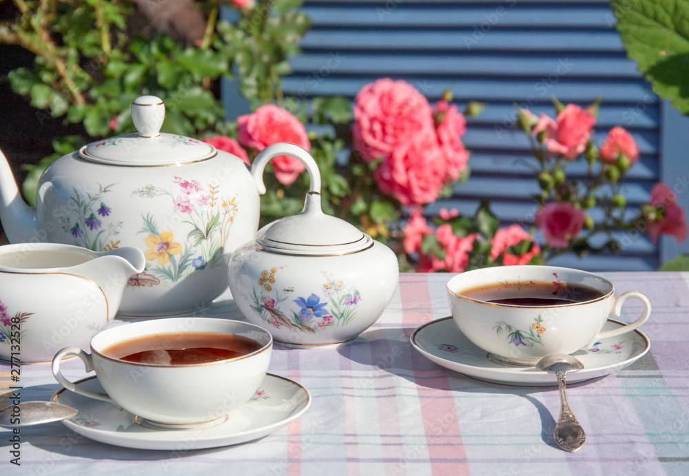 Tea in the English style on the background of roses