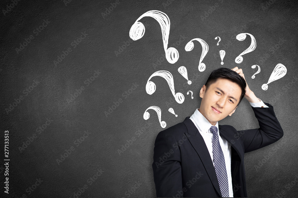 confused young businessman scratching his head with question mark