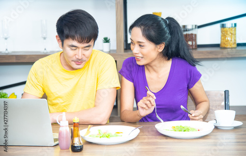 Happy family. Asian lovely couple, beautiful woman and handsome man are having breakfast in the kitchen