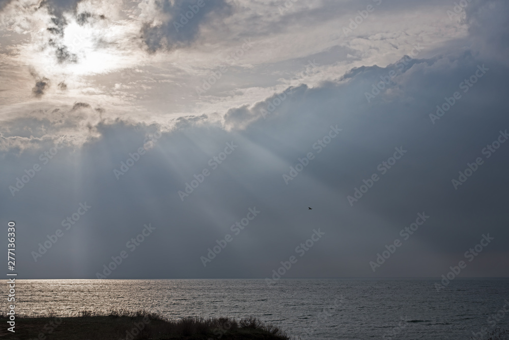 The sea surface in the rays of sunlight on a cloudy day. The sea in the rays of the sun coming through the clouds 