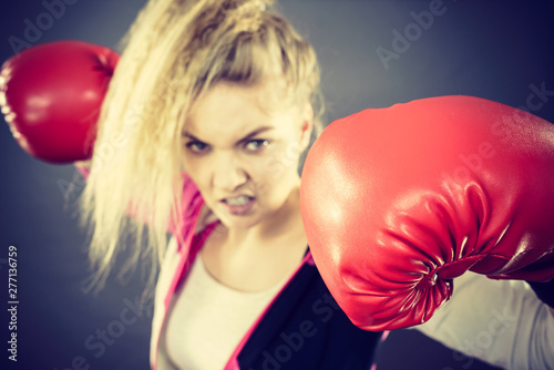 Angry woman wearing boxing gloves © Voyagerix